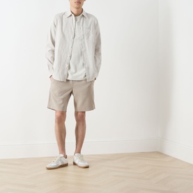 Model wearing Samsoe & Samsoe Smith Lightweight Shorts in Aluminium, styled with a linen shirt and white trainers.