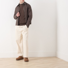 Model wearing Samsoe & Samsoe Joel Logo Sweatshirt in Turkish Coffee, styled with brown zip jacket, cream trousers and tan suede shoes.