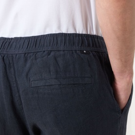 Model wearing Samsoe & Samsoe Jabari Casual Trousers in Salute, showing rear patch pocket and elasticated waistband detail, styled with white tee.