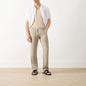 Model wearing Samsoe & Samsoe Jabari Regular-Fit Trousers in Aluminium linen, styled with white short-sleeve shirt, beige tee and dark sandals.