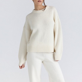 Model wearing House of CB ivory knit crew neck sweater with ribbed hem and cuffs, styled with matching knit trousers