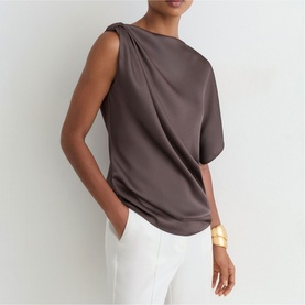 Model wearing Reiss purple satin draped sleeveless top, styled with white trousers and a gold cuff bracelet