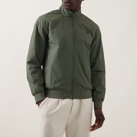 Model wearing Fred Perry Brentham Logo Overshirt in Laurel Wreath Green with funnel neck, zip fastening and ribbed cuffs, styled with cream trousers.