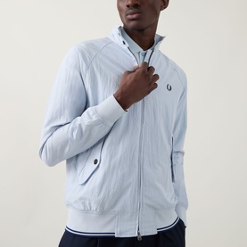 Model wearing Fred Perry Dusky Blue casual jacket with ribbed hem and cuffs, zip fastening, and embroidered logo on chest