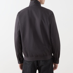 Model wearing Fred Perry Laurel Wreath Harrington Jacket in Anchor Grey, rear view, showing zip back, ribbed hem, paired with dark jeans