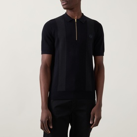 Model wearing Fred Perry Panel Detail Knitted Polo Shirt in Black with half-zip placket, waffle-stitch panels and short sleeves.