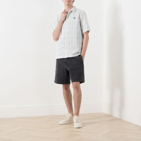 Model wearing Fred Perry Seersucker Check Shirt in Ecru with dark grey shorts and white trainers.