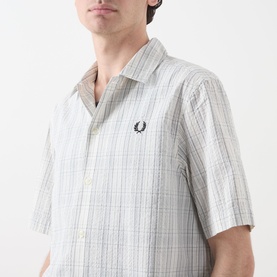 Model wearing Fred Perry Seersucker Check Shirt in Ecru, short sleeves, two-tonal check pattern, embroidered laurel wreath on chest