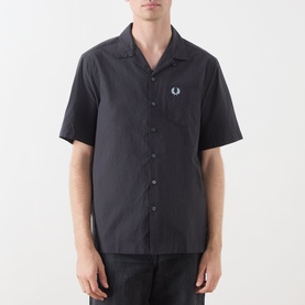 Model wearing Fred Perry Anchor Grey casual shirt with camp collar, short sleeves, chest pocket and embroidered logo