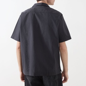 Model wearing Fred Perry Anchor Grey short-sleeve casual shirt, rear view, relaxed fit with open collar and cropped hem.