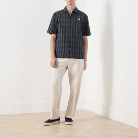 Model wearing Fred Perry Navy check short-sleeve casual shirt with white trousers and navy loafers
