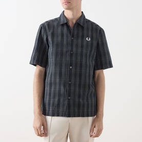 Model wearing Fred Perry navy check cotton casual shirt with short sleeves, button-front, and embroidered laurel wreath logo on chest