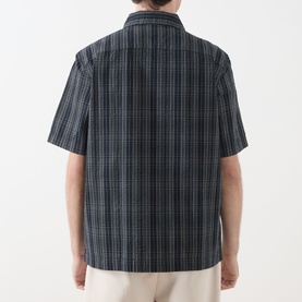Model wearing Fred Perry Navy Casual Shirt, back view, short-sleeve navy check cotton design with relaxed fit, styled with cream trousers.