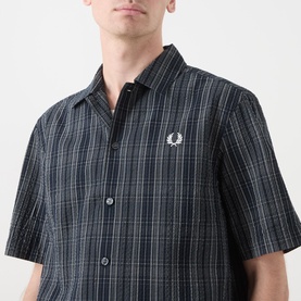Model wearing Fred Perry navy check casual shirt, short sleeve, button-front with embroidered laurel wreath logo at chest