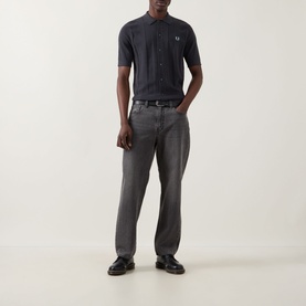Model wearing Fred Perry Anchor Grey cotton casual shirt with grey jeans and black loafers