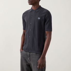 Model wearing Fred Perry Anchor Grey cotton knit casual shirt with button-through front, short sleeves, and embroidered laurel wreath logo, styled