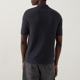 Model wearing Fred Perry Anchor Grey cotton knit casual shirt, rear view, styled with grey jeans