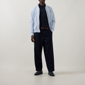Model wearing Fred Perry Navy Crew Neck T-Shirt, styled with light blue zip-through jacket, navy trousers, brown belt and black loafers.