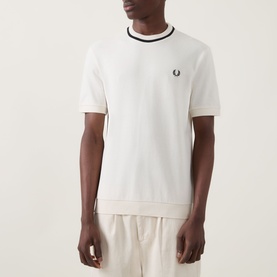 Model wearing Fred Perry Crew Neck T in Ecru, with dark tipping detail at collar and cuffs, small laurel wreath logo at chest.