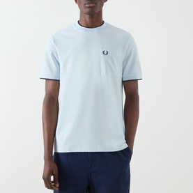 Model wearing Fred Perry Crew Neck T-Shirt in Light Ice, featuring tipped collar and cuffs with embroidered laurel wreath logo.