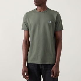 Model wearing Fred Perry Ringer Laurel Wreath T-Shirt in Laurel Wreath Green, crew neck with chest logo, paired with dark jeans.