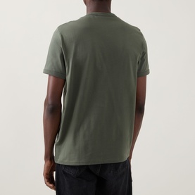 Model wearing Fred Perry Ringer Laurel Wreath T-Shirt in Laurel Wreath Green, rear view, crew neck, short sleeves, paired with black trousers