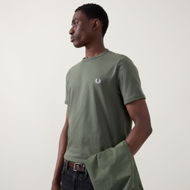 Model wearing Fred Perry Ringer Laurel Wreath T-Shirt in Laurel Wreath Green with crew neck and chest logo, styled with dark trousers.