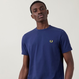 Model wearing Fred Perry Ringer Laurel Wreath T-Shirt in French Navy with crew neck and gold laurel wreath chest logo.