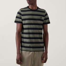 Model wearing Fred Perry Black Striped Crew Neck T-Shirt in cotton, featuring bold horizontal stripes with small laurel wreath logo at chest.