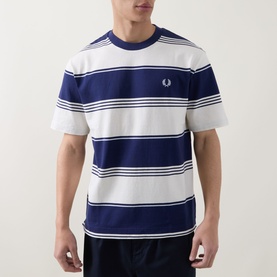 Model wearing Fred Perry Heavy-Striped Laurel Wreath Logo T-Shirt in Ecru, navy bold horizontal stripes, crew neck, embroidered logo to chest.