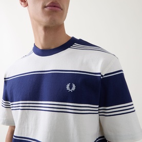 Model wearing Fred Perry Heavy-Striped Laurel Wreath Logo T-Shirt in Ecru with navy bold stripes and embroidered chest logo.