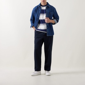 Model wearing Fred Perry Heavy-Striped Laurel Wreath Logo T-Shirt in Ecru, styled with denim overshirt, navy trousers and white trainers.