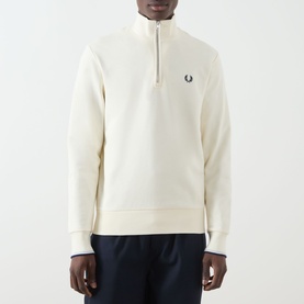Model wearing Fred Perry Ecru Half Zip sweatshirt with Dusky Blue tipped cuffs and French Navy quarter-zip detail, styled with navy trousers.
