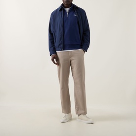 Model wearing Fred Perry Wreath Logo Half-Zip Sweatshirt in French Navy, styled with beige trousers and white trainers.