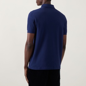 Model wearing Fred Perry Twin Tipped Fred Perry Polo Shirt in French Navy, rear view showing short sleeves and straight hem.