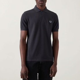 Model wearing Fred Perry Twin Tipped Polo Shirt in Anchor Grey, short sleeves, two-button placket, Laurel Wreath chest logo