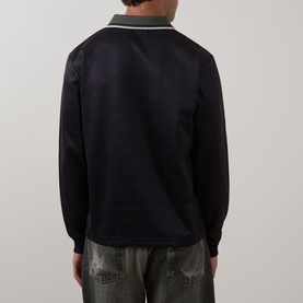 Model wearing Fred Perry Meyba Long-Sleeve Polo in black, rear view, with grey flat collar, ribbed cuffs, styled with khaki trousers.