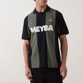 Model wearing Fred Perry Meyba Cut & Sew Polo Shirt in black with khaki vertical stripes and large MEYBA chest graphic print.