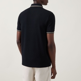Model wearing Fred Perry Laurel Logo Twin Tipped Polo Shirt in black with oatmeal twin tipping on collar and cuffs, rear view