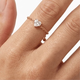Lynott Jewellery ring with pear-cut crystal stone on rose gold chain band, worn on finger