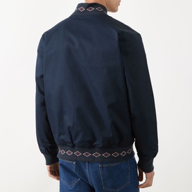Model wearing Scotch & Soda Reversible Printed Bomber Jacket in Sky Captain, rear view showing diamond-print ribbed hem and collar trim, styled with