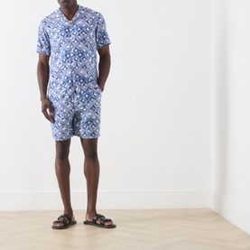 Model wearing Scotch & Soda Tiles Flower casual shirt in blue geometric print, styled with matching shorts and brown sandals.