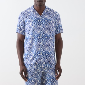 Model wearing Scotch & Soda casual shirt in Tiles Flower blue geometric print, short sleeves, camp collar, with matching shorts visible