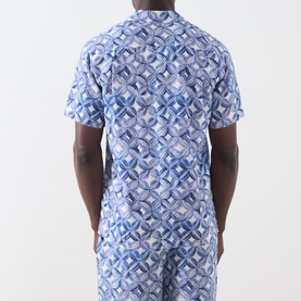 Model wearing Scotch & Soda casual shirt in Tiles Flower print, blue geometric pattern, short sleeves, paired with matching shorts.