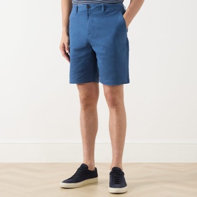 Model wearing Scotch & Soda Ensign Blue chino shorts, styled with a striped shirt and navy canvas trainers.