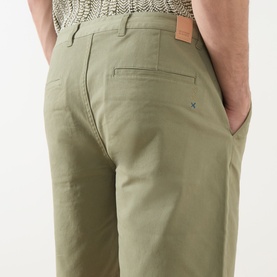 Model wearing Scotch & Soda Oil Green 300 chino shorts, rear view showing back pocket and logo tab detail.