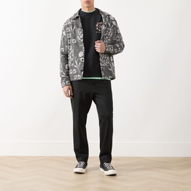 Model wearing Scotch & Soda Floral Graphic Logo Sweatshirt in Meteorite, styled with a grey printed jacket and black trousers.