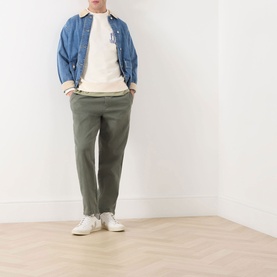 Model wearing Scotch & Soda Work-Out Art Logo Sweatshirt in Eggnog, styled with blue overshirt, olive trousers and white trainers.
