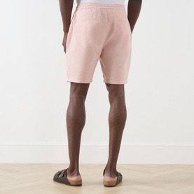 Model wearing Scotch & Soda Fave Bermuda Shorts in Misty Rose, elasticated waistband, rear welt pockets, styled with brown sandals