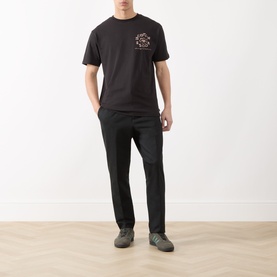 Model wearing Scotch & Soda Floral Graphic T-Shirt in Meteorite with chest logo graphic, styled with black trousers and grey trainers.